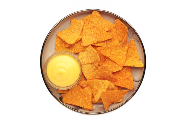 Tasty nachos with cheese sauce isolated on white background. Top view