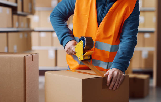 istock Warehouse employee taping a delivery box 2165645387