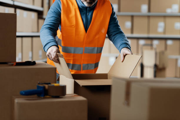 istock Warehouse operative opening a carton box 2165645782