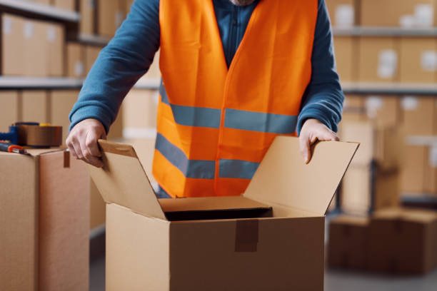 istock Warehouse operative opening a carton box 2165645955