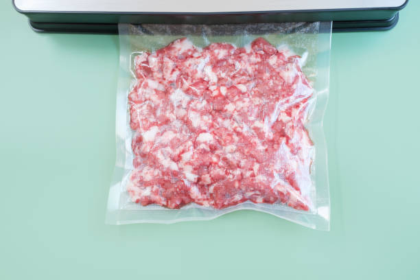 istock Minced meat in a vacuum bag on a green background close-up. 2165651019