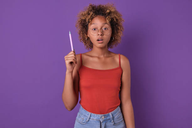 istock Creative Young Woman Deep in Thought Against a Vibrant Purple Backdrop 2165651670