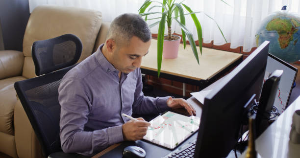 istock Businessman working in the office on stock market exchange data using desktop computer and digital tablet 2165655190