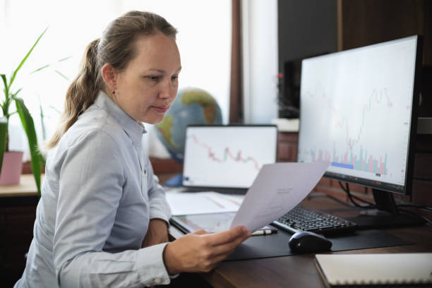 istock Business woman working in the office on stock market exchange data using desktop computer and digital tablet 2165656072