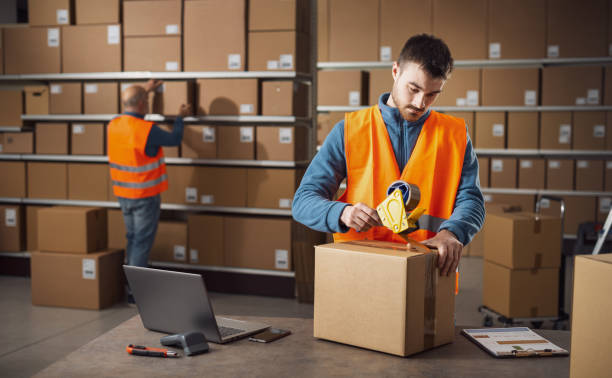 istock Worker sealing a box at the warehouse 2165659969