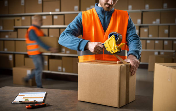 istock Worker sealing a box at the warehouse 2165661682