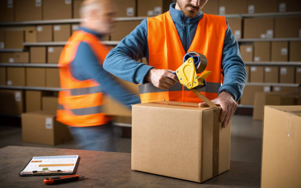 istock Worker sealing a box at the warehouse 2165661698