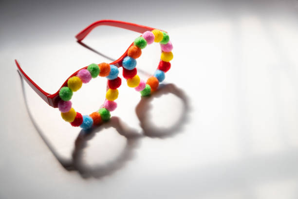Party glasses with multi-colored pompoms, with copy space