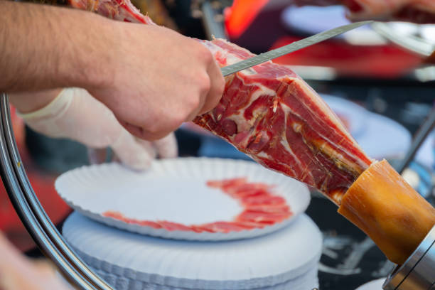 Ham cutting master, professional knife master, Cortador de jamon, man cutting jamon ham placed in a stand, gastronomy