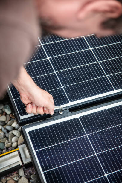 istock a male craftsman or electrician installs solar modules 2165668763