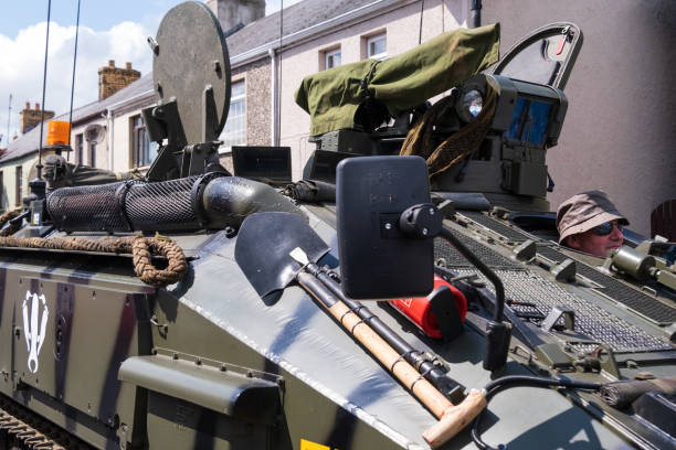 Broughshane, UK - June 3rd, 2022: Man driving a green camouflaged armoured tank as part of procession through the village marking the Platinum Jubilee of Queen Elizabeth II.