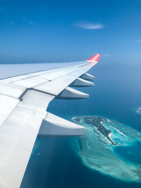 istock Maldives islands top view from airplane window with airplane's wing 2165672654