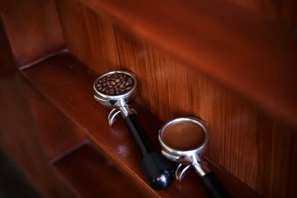 Ground coffee and roasted coffee beans in portafilter holder with background. Close up