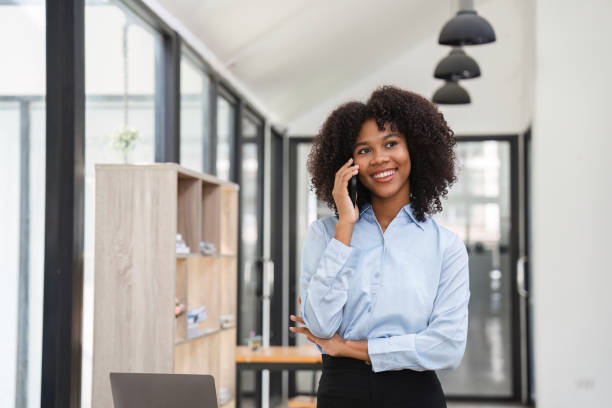 istock Young Female Accountant Using Telephone in Modern Office Environment for Professional Communication 2165674703