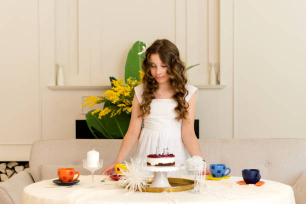 White swan Candy Bar. Delicious sweet buffet with tiered cake. Cute little girl taking sweets from the candy bar.