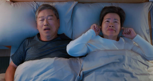 husband snore wife cannot sleep Closeup top view of asian elderly couple - husband snore while sleeping and wife cannot sleep feel irritable man sleeping top view stock pictures, royalty-free photos & images