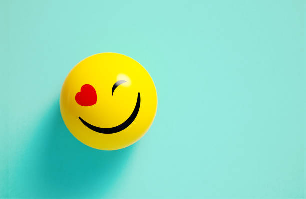 istock Yellow Sphere Textured With Happy Face Emoji On Blue Background 2165680309
