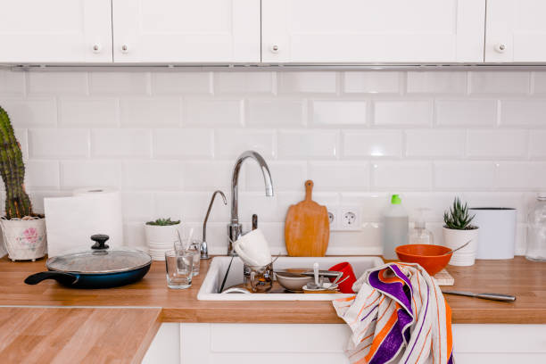 istock Clutter, dirty dishes by the sink in the white kitchen 2165681406