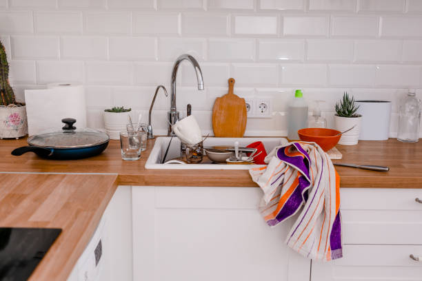 istock Clutter, dirty dishes by the sink in the white kitchen 2165681410