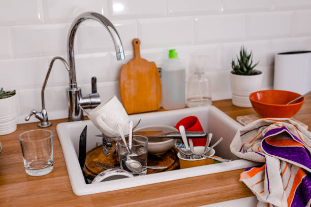 istock Clutter, dirty dishes by the sink in the white kitchen 2165681447