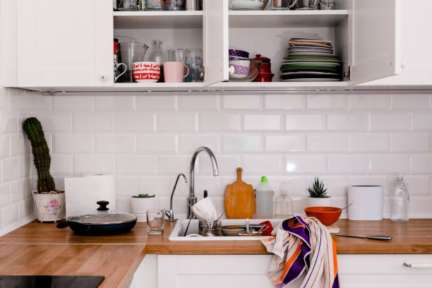 istock Clutter, dirty dishes by the sink in the white kitchen 2165681470