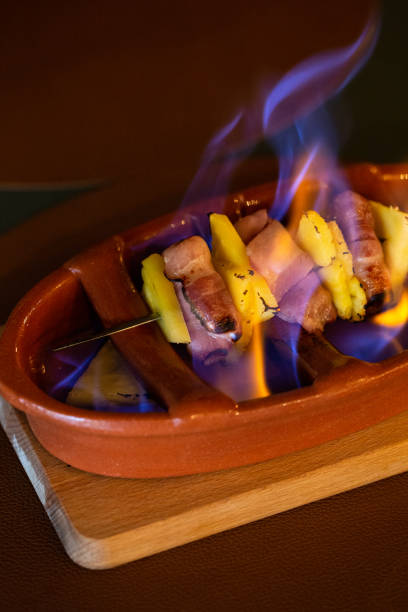 istock Flaming a Pineapple with Bacon Skewered in a Restaurant table, Braga, Portugal. 2165683272