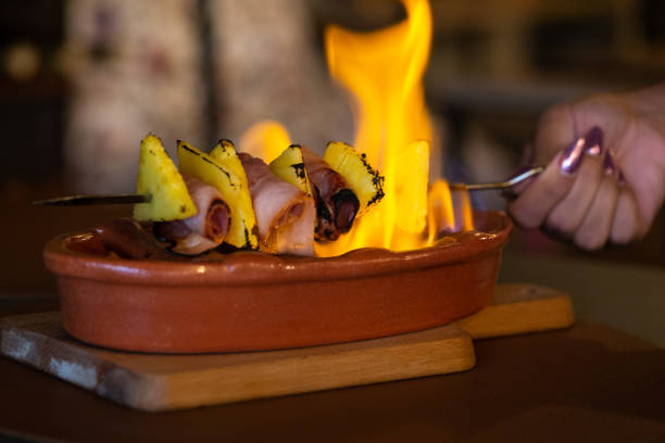 Flaming a Pineapple with Bacon Skewered in a Restaurant table, Braga, Portugal.