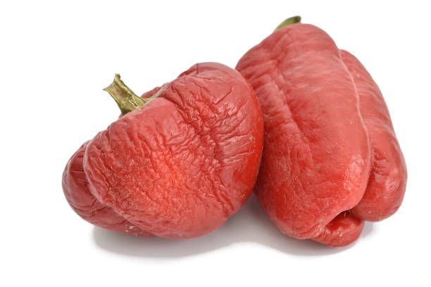 Two bell peppers with wrinkled skin. Damaged by high temperature.