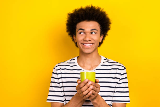 istock Photo of young relaxing guy hold cup tea aroma drinking looking empty space coffee break cafeteria isolated on yellow color background 2165687933