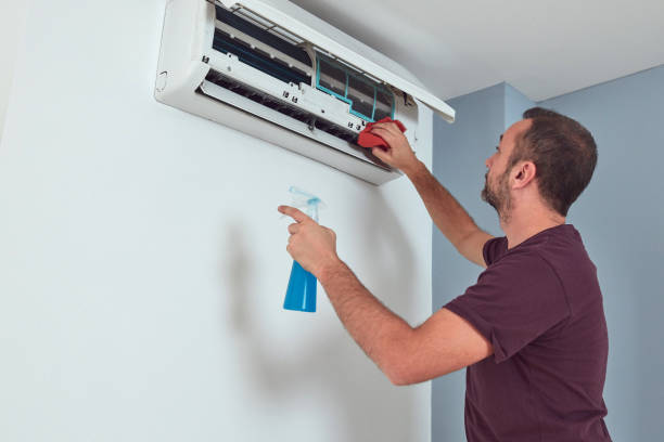 istock Man cleaning and maintaining air condition unit. 2165690491