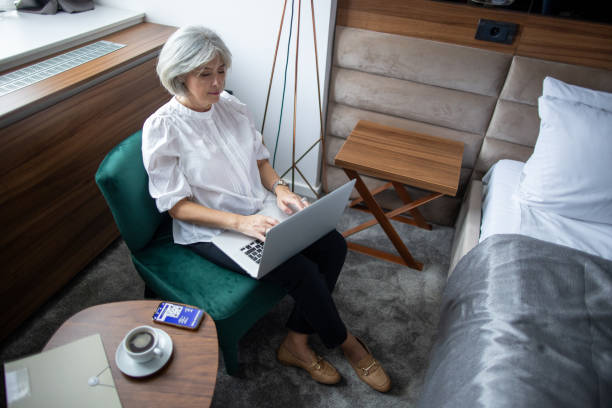istock Mature woman working in hotel room 2165692083