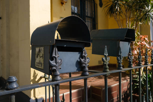 Black metal mailboxes on fence on a sunny dan.