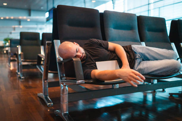istock Young man sleeping at the airport while waiting for his flight 2165698463