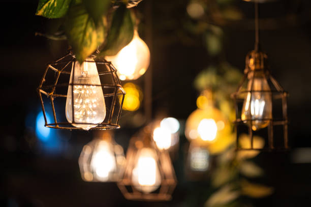 istock Ceiling lighting bulb with iron cage glowing in orange warm light. interior decoration. 2165704729