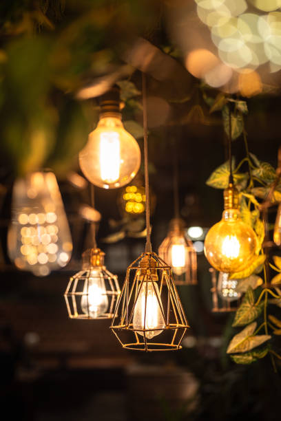 istock Ceiling lighting bulb with iron cage glowing in orange warm light. interior decoration. 2165704750