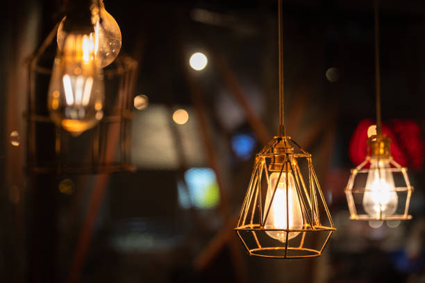 istock Ceiling lighting bulb with iron cage glowing in orange warm light. interior decoration. 2165704756