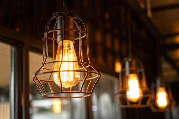 istock Ceiling lighting bulb with iron cage glowing in orange warm light. interior decoration. 2165704960