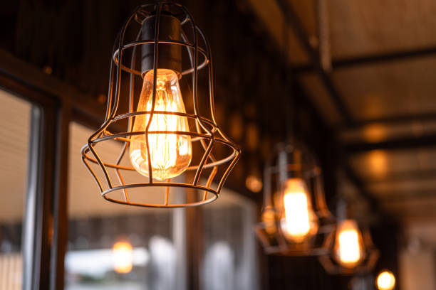 istock Ceiling lighting bulb with iron cage glowing in orange warm light. interior decoration. 2165705030