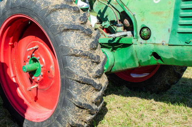 Family agricultural farms are a thriving tradition in the southwest Missouri region of the USA. This close up look at a grass covered tractor tire depicts old yet usable equipment. Bokeh.
