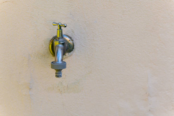 a silver faucet is on a wall