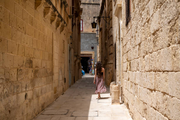 Woman explores old town streets, Mdina, Rabat, Malta