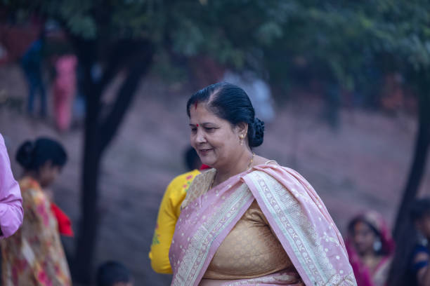 Ghaziabad, Uttar Pradesh, India - November 2023: Chhath Puja, Group of indian woman sitting on ground to perform the rituals of chhath puja in traditional ethnic clothes.