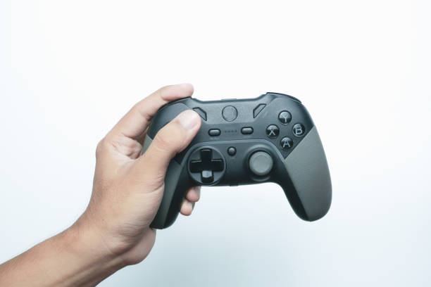 istock Hand holding a gamepad or joystick against a white background with empty copy space for text or advertisement 2165725935
