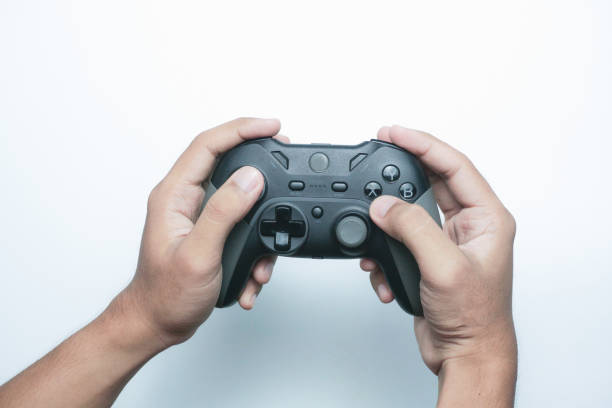 istock Hand holding a gamepad or joystick against a white background with empty copy space for text or advertisement 2165726060