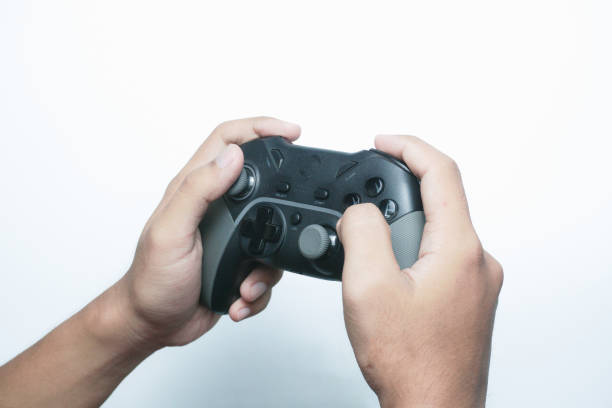 istock Hand holding a gamepad or joystick against a white background with empty copy space for text or advertisement 2165726126