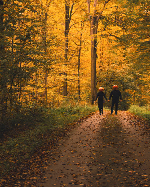 istock couple with pumpkin head in fall forest 2165727214