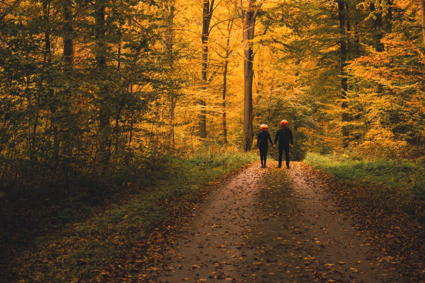 istock couple with pumpkin head in fall forest 2165727216