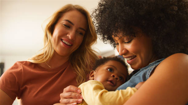 istock Two Women Joyfully Interacting With a Baby in a Cozy Indoor Setting 2165728416