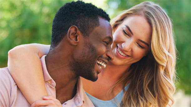 istock Happy Couple Embracing Outdoors in a Sunlit Park During Afternoon 2165730101