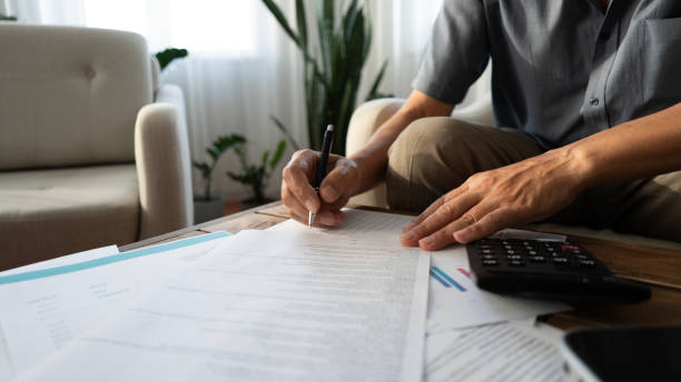 istock Senior man hand signing contract at home 2165732205